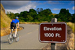 Picture: Bicycle rider going uphill on road past elevation marker sign, Mount Diablo State Park, California 