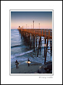 Surfers checking out the waves next to Oceanside Pier, San Diego County Coast, California