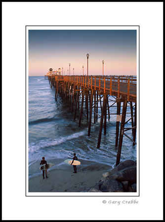 Surfers checking out the waves next to Oceanside Pier, San Diego County Coast, California