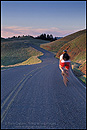 Picture: Cyclist biking on twisting road, in the hills of Marin County, California