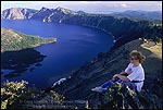 Photo: Tourist overlooking Crater Lake from high on the rim near The Watchman, Crater Lake National Park, Oregon