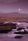 Full moon rising in evening sky over coastal hills near San Simeon, Central Coast, California