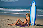 Beautiful young tan blonde woman in bikini sunbathing and surfboard at Manhattan Beach, Los Angeles County, Southern California Coast