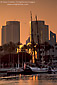 Sailing ship docked below city high rise office buildings in downtown at sunset, Long Beach Harbor, California