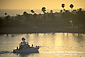 Luxury yacht returning from sea in harbor channel at sunset, Corona del Mar, Newport Beach, California