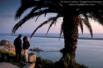 Tourist Couple looking out over Pacific Ocean at sunset, from Inspiration Point overlook, Corona del Mar, Newport Beach, California