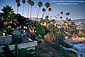 Sunset light along palm tree lined promenade and coastal cliffs at Heisler Park, Laguna Beach, Orange County, California