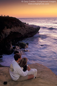 Couple watching the sunset over the Pacific Ocean from coastal bluff at Scripps Park, La Jolla, San Diego County Coast, California