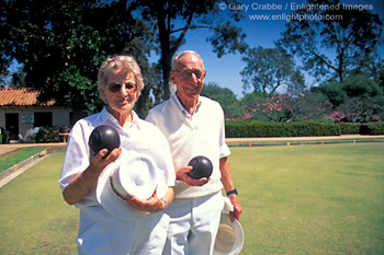 Elderly couple poses holding Bocce Balls at Bocce Ball court in Balboa Park, San Diego, California