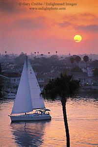 Catalina sailboat heading out to sea at sunset out of Newport Beach Harbor, Newport Beach, California
