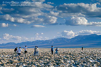 Tourists walking on rugged salt crust at Devils Golf Course, Death Valley National Park, California; Stock Photo image picture photo Phograph art decor print wall mural gallery