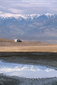 Truck towing RV Camper trailer below mountains reflected in spring water pool at Badwater, Death Valley National Park, California; Stock Photo image picture photo Phograph art decor print wall mural gallery