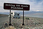 Tourists drive RV camper off road and get stuck in rocks next to warning sign, near Badwater, Death Valley National Park, California