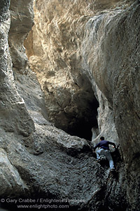 Hiker climbing rock wall into narrow Grotto Canyon, Death Valley National Park, California; Stock Photo image picture photo Phograph art decor print wall mural gallery