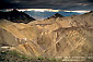 Sunbeams and dark storm clouds over eroded hills in Golden Canyon, Death Valley National Park, California