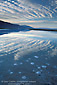 Morning clouds reflected in water flooded basin in spring, Death Valley National Park, California