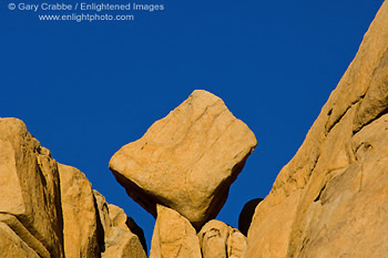 Eroded rock boulder balanced in wedge on outcrop near Barker Dam, Joshua Tree National Park, California