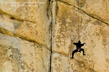 Rock climber climbing at Hidden Valley, Joshua Tree National Park, California