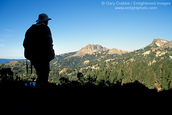 Hiker overlooking mountain peaks and forest on trail to Bumpass Hell, Lassen Volcanic National Park, California; Stock Photo photography picture image photograph fine art decor print wall mural gallery