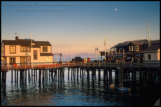 Moonrise at sunset over buildings on Stearns Wharf, Santa Barbara, California