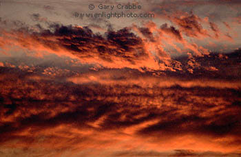 Cirrus and cumulus storm clouds turn red at sunset over central California