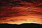 Alpenglow turns altostratus storm clouds red at sunrise, Eastern Sierra, California