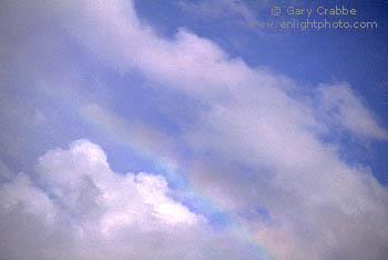 Rainbow and blue sky beneath clearing storm clouds