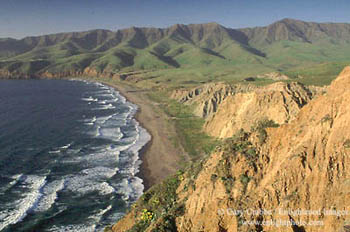 Green hills in spring surround the waves breaking on Christies Beach, Santa Cruz Island, Channel Islands, California