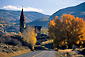 Church steeple, road, and fall colors on tree in autumn, Aspen, Rocky Mountains, Colorado