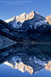 Sunrise light on snow covered mountains reflected in alpine lake on a clear morning, Maroon Bells Wilderness, near Aspen, Rocky Mountains, Colorado