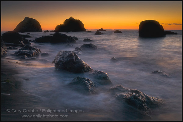 Sunset light over seastacks and coastal rocks on beach at False Klamath Cove, Redwood National Park, California