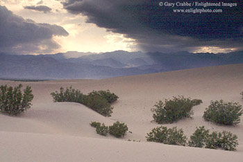 Sunlight through storm clouds over sand dunes at Stovepipe Wells, Death Valley National Park, California