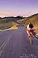 Biker on twisting road at sunset, Marin County, California