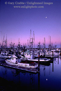 Moonset at dawn over fishing boats in Crescent City Harbor, California