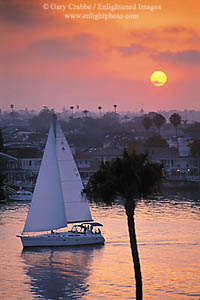 Catalina sailboat heading out to sea at sunset out of Newport Beach Harbor, Newport Beach, California