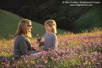 Mother and Daughter in field of wildflowers at sunset, Marin County, California