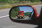Photo: Red tractor trailer semi truck rig in rearview mirror on highway, Upstate New York