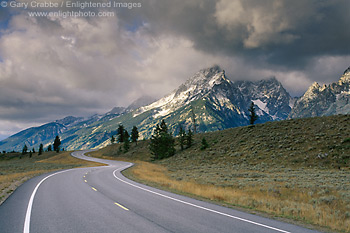 Photo: Twisting curve on road beneath storm clouds and mountains, Grand Teton National Park, Wyoming