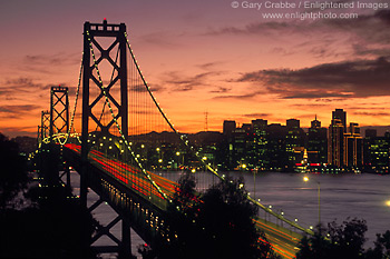 Photo: Suspension Bridge section of the Oakland San Francisco Bay Bridge at sunset with city skyline, California