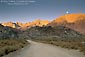 Photo: Moonset and alpenglow on mountains over dirt road in the Eastern Sierra, near Bishop, California