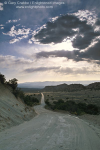 Image: Clouds and sunbeams in blue sky over dirt road, Escalante Region, Utah