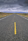 Picture: Storm clouds over long straight empty desert two lane paved highway near Lake Powell, Utah