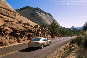 Image: Car driving on road below Checkerboard Mesa, Zion National Park, Utah