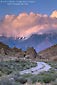 Photo: Alpenglow on clouds at sunset over mountains and dirt road in the Eastern Sierra, California