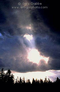 Sunbeam bursts through storm clouds at sunrise, Grand Teton National Park, Wyoming