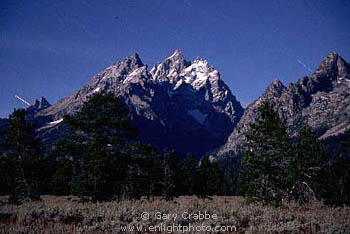 Star trails over the Grand Tetons at night by the light of the full moon, Grand Teton National Park, Wyoming