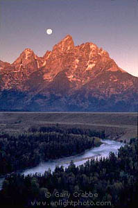 Alpenglow at sunrise as the full moon sets over the Teton Range and Snake River, Grand Teton National Park, Wyoming