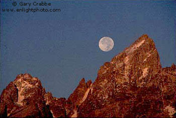 Full moon sets over the Grand Teton at sunrise, Grand Teton National Park, Wyoming