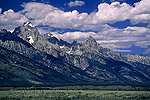 Picture: Blue sky and puffy white clouds over steep rising mountains at Grand Teton National Park, Wyoming