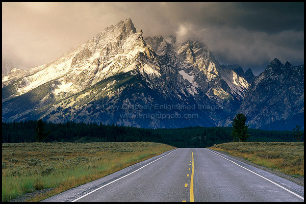 Photo: Straight road below mountain range dusted by first snow of fall, Grand Teton National Park, WYOMING